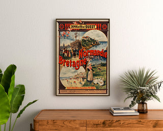 Normandian vintage-juliste – Normandia ja Bretagne — Ouestin rautatiet, kehystettynä puupöydän yläpuolella kasvien välissä.