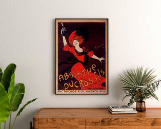 Vintage-mainosjuliste Absinthe Ducros, kehystetty puukaapin yläpuolelle kasvien väliin.