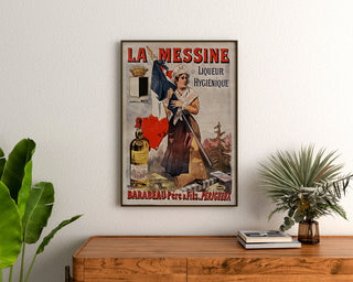 Vintage-mainosjuliste La Messine, likööri, kehystettynä puupöydän yläpuolella kasvien välissä.