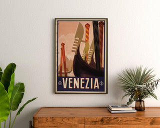 Vintage-matkailujuliste – Venezia, gondolien keulat, kehystetty puisennon lipaston yläpuolelle kasvien väliin.