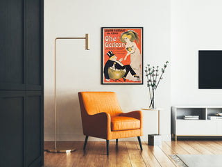 Vintageseinäjuliste Casino Kursaal, "Ohé Gédéon", kehystetty olohuoneessa oranssin nojatuolin ja lattiavalaisimen kanssa.