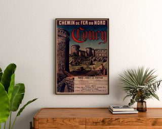Vintageljuliste Coucy, Chemins de fer du Nord, kehystetty puukommodin yläpuolelle kasvien väliin.