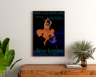 Vintagijuliste La Revue illustrée, kehystettynä puukomuutin yläpuolella kasvien välissä.