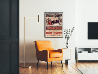 Vintage-juliste Mont-de-Marsan, juhlat ja kisat, kehystetty olohuoneessa oranssin keinutuolin ja lattiavalaisimen vieressä.