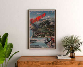 Vintagetyylinen Mont-Revard -juliste, hammasrattailla kulkeva rautatie, kehystettynä puukomodin yläpuolella kasvien ympäröimänä.