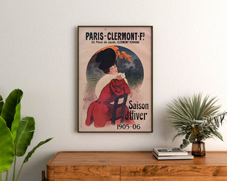 Vintage-juliste Paris-Clermont, talvikausi, kehystettynä puukomodin yläpuolelle kasvien väliin.
