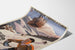 Vintagetyylinen Saint-Gervais, Mont-d’Arbois -juliste, esitettynä kaartuvalla paperilla perspektiivistä nähtynä.